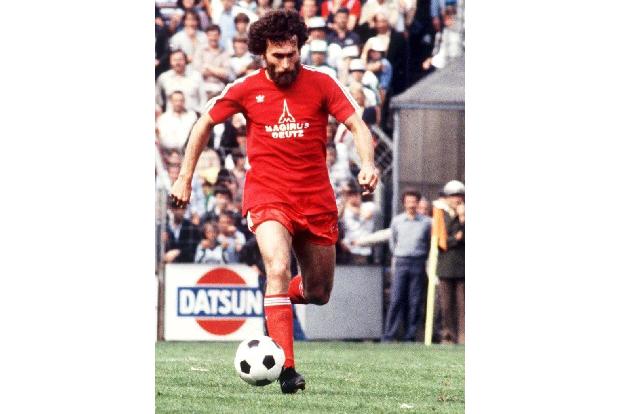 Und wieder in Signalfarben. Paul Breitner rennt mit dem Ball über das Feld.