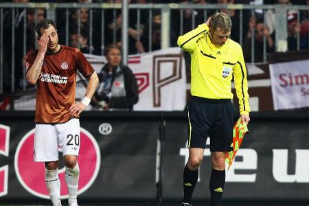 Während der Bundesligapartie zwischen St. Pauli und Schalke 04 wird Schiri-Assistent Thorsten Schiffner von einem Bierbecher...