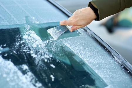 Eiskratzer an der Autoscheibe Eiskratzer an der Autoscheibe