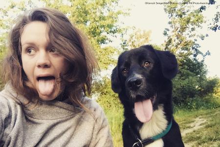 Frau und Hund mit ausgestreckter Zunge