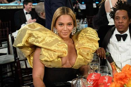 Sängerin Beyoncé erschien in einem figurbetonten schwarzen Kleid mit gewaltigen goldenen Puffärmeln zur Veranstaltung.