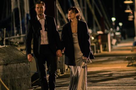 Christian Grey (J. Dornan) und Anastasia Steele (D. Johnson) haben keine Lust mehr, auf die schicke Party und spazieren lieb...