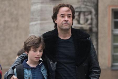 Rainer (Jan Josef Liefers) überrascht seinen Sohn Daniel (Serafin Mishiev) nach der Schule