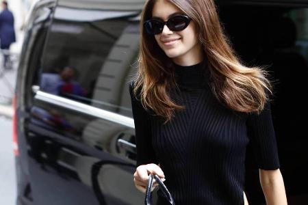 Stylisch unterwegs: Kaia Gerber mit Rollkragenoberteil, Sonnenbrille und Mini-Bag