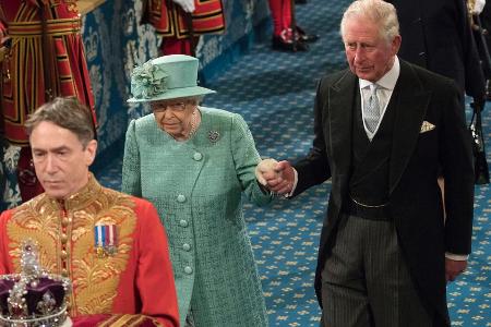 Setzte die Krone im Parlament nicht auf: Die Queen an der Hand von Prinz Charles Setzte die Krone im Parlament nicht auf: Die Queen an der Hand von Prinz Charles