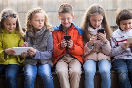 Typische Körperhaltung bei Erwachsenen und zunehmend auch Kindern: Kopf nach unten, Smartphone vorm Gesicht Typische Körperhaltung bei Erwachsenen und zunehmend auch Kindern: Kopf nach unten, Smartphone vorm Gesicht