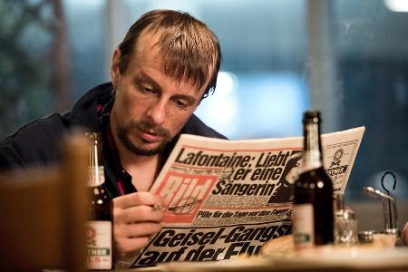 Die Medien berichten über die spektakuläre Geiselnahme: Dieter Degowski (Alexander Scheer) liest über sich in der Die Medien berichten über die spektakuläre Geiselnahme: Dieter Degowski (Alexander Scheer) liest über sich in der