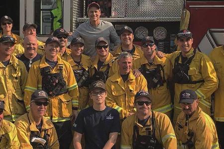 Rob Lowe (hinten Mitte) und sein Sohn Matthew (vorne Mitte) mit den Feuerwehrleuten Rob Lowe (hinten Mitte) und sein Sohn Matthew (vorne Mitte) mit den Feuerwehrleuten