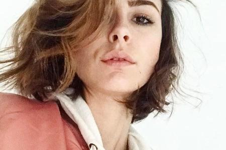 Lena Meyer-Landrut kombiniert eine altrosa Bomberjacke zu einem cremeweißen Hoodie