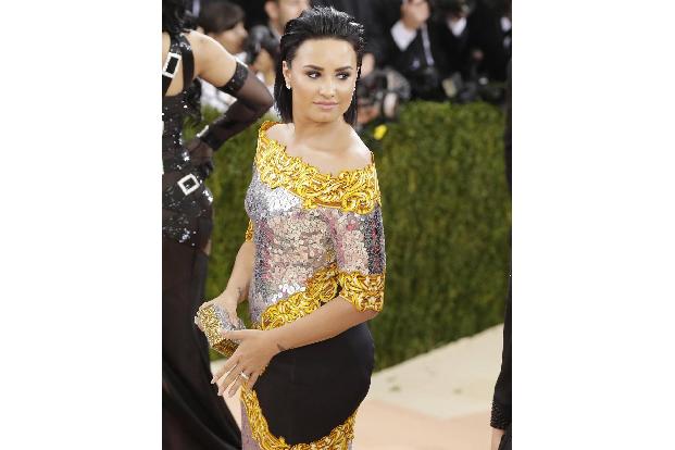 Demi Lovato kam zur Met Gala in einem silbernen Kleid von Moschino mit gelb-goldenen Verzierungen.