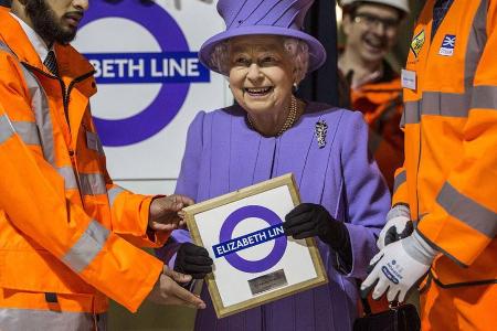 Stolz hält Queen Elizabeth II das Schild der neuen U-Bahn-Linie mit ihrem Namen hoch Stolz hält Queen Elizabeth II das Schild der neuen U-Bahn-Linie mit ihrem Namen hoch