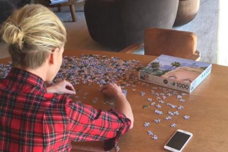 Ellen DeGeneres schaut ihrer Frau Portia beim Puzzeln über die Schulter Ellen DeGeneres schaut ihrer Frau Portia beim Puzzeln über die Schulter