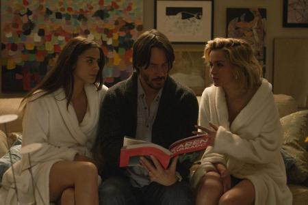 Genesis (Lorenza Izzo), Evan (Keanu Reeves) und Bel (Ana De Armas, v.l.) betrachten das Kunstbuch seiner Frau.