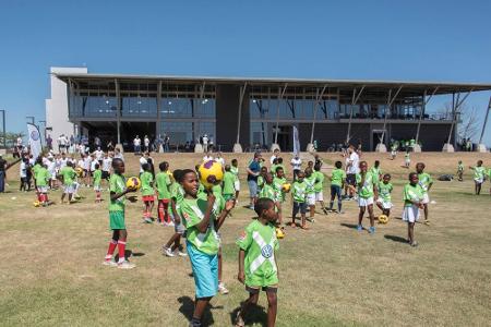 Fußball spielende Kinder auf dem Rasen vor dem People Pavilion in Uithage