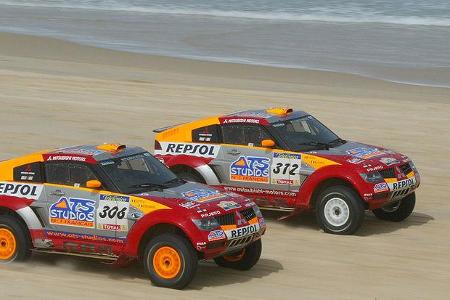Zwei Mitsubishis in auffälliger Repsol-Lackierung.