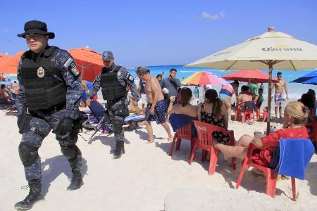 Mexican Police agents patrol amongs the tourists at a beach ... Mexican Police agents patrol amongs the tourists at a beach ...