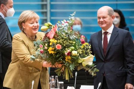 Angela Merkel freut sich über die Abschiedsblumen von Olaf Scholz. Angela Merkel freut sich über die Abschiedsblumen von Olaf Scholz.