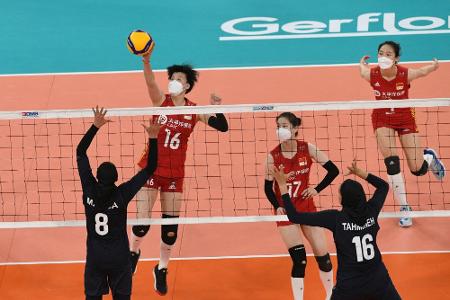 Chinesische Volleyballerinnen spielen mit Masken Chinesische Volleyballerinnen spielen mit Masken