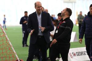 Strahlender Prinz William verbreitet gute Laune im Fußballzentrum