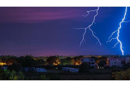 Two large and powerful lighting strikes crossing night blue sky Two large and powerful lighting strikes crossing night blue sky