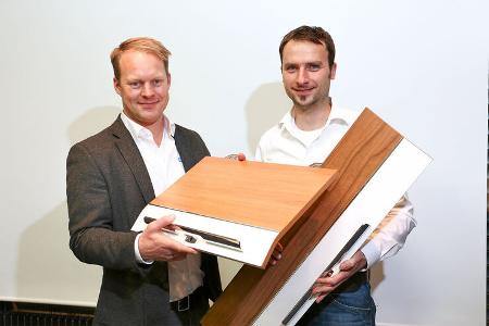 Geschäftsbereichsleiter Berg und Produktmanager Wingart präsentieren erste Möbeldekore des neuen Reisemobils.