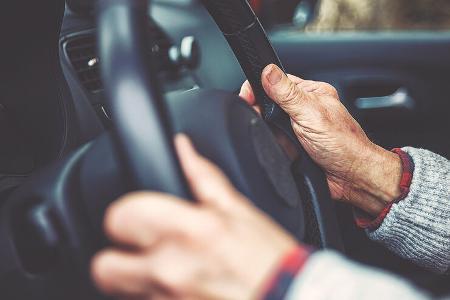 The hand of an elderly gentleman on the steering wheel The hand of an elderly gentleman on the steering wheel
