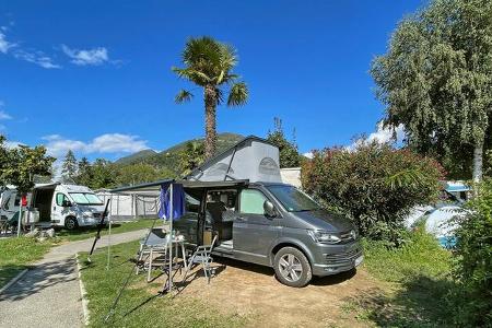Campingplatz, Campingvans, Tisch, Stühle, Palmen, Berge, Himmel 