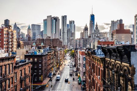 Straßenzug in New York mit der Skyline im Hintergrund.