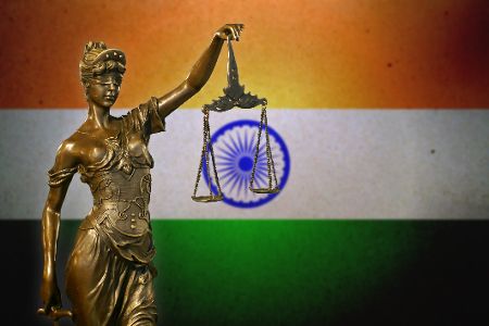 Figur von Justitia vor indischer Flagge