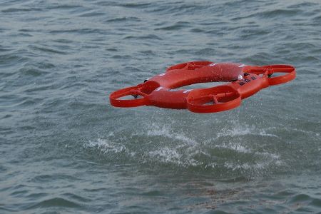 Rote Drohne fliegt über Wasser Rote Drohne fliegt über Wasser
