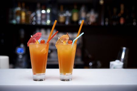 Zwei Drinks mit Schirmchen und Strohhalm in einem CLub Zwei Drinks mit Schirmchen und Strohhalm in einem CLub