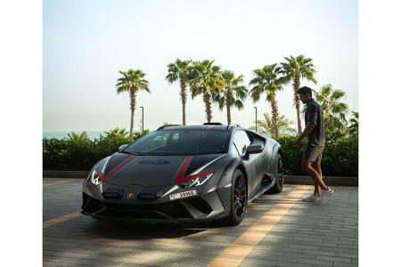 Mann präsentiert Modekollektion von Lamborghini und Orlebar Brown.