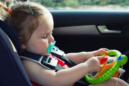 Kind mit Spielzeug im Auto