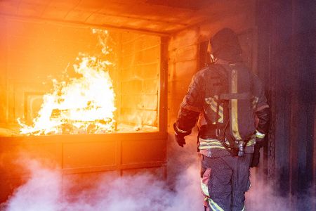Ein Proband mit einem Prototyp einer intelligenten Feuerwehrjacke in der Brandsimulationsanlage Ein Proband mit einem Prototyp einer intelligenten Feuerwehrjacke in der Brandsimulationsanlage
