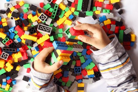 Kinderhände spielen mit Legosteinen