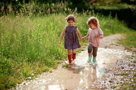Zwei Kinder spielen in einem Bach