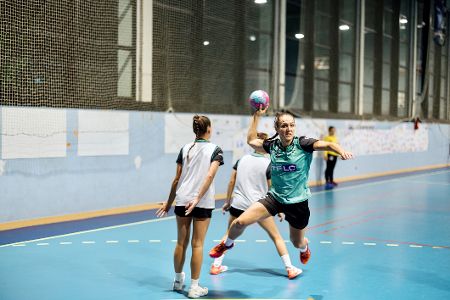 Junge Handballspielerin springt zum Wurf ab