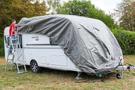 Die Schutzhülle wird von vorne nach hinten über den Caravan gezogen.