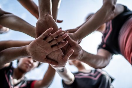 Sportlerinnen halten ihre Hände zusammen