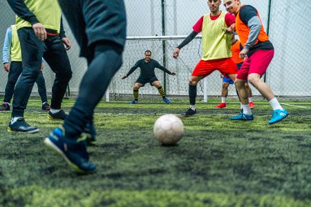 Freizeitfußballer in der Halle auf Kunstrasen beim Torschuss