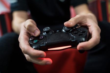 Ein Gamer spielt mit einer Playstation 4.