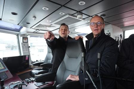 Unionskanzlerkandidat Friedrich Merz lässt sich vom Inhaber des Hamburger Unternehmens VB Group beim Besuch des Feuerlöschboots 