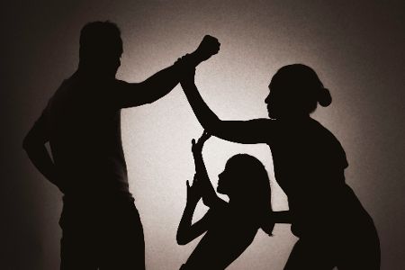 Silhouette von einem Mann, der seine Frau und Tochter schlagen will Silhouette von einem Mann, der seine Frau und Tochter schlagen will