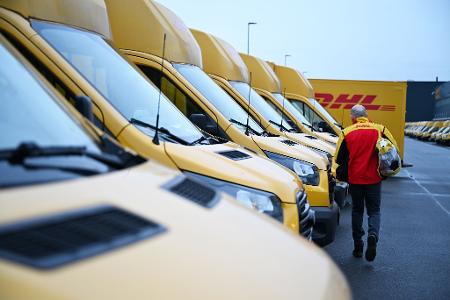 Auch er fährt Stromer: ein DHL-Paketbote auf dem Weg zu seinem Elektro-Transporter.