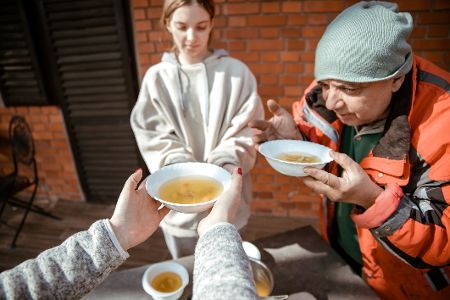 Bedürftiger Mann und Kind erhalten Suppe