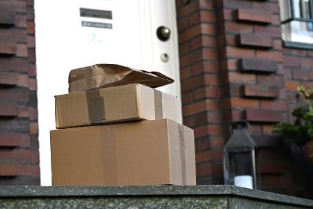 Drei Pakete liegen vor einer Haustür - für Paketfirmen ist dieser Lieferweg eine teure Sache. (Archivbild)