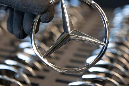 Hand hält einen Mercedes-Stern Hand hält einen Mercedes-Stern