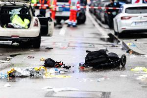 Kleidung und ein Kinderwagen liegen nach dem Anschlag auf der Straße.