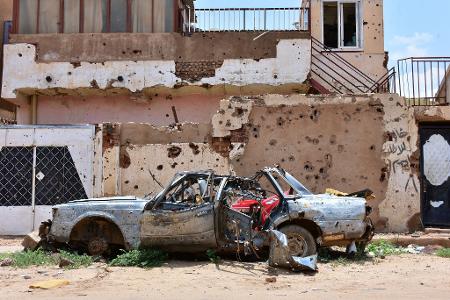 Ein zerstörtes Auto steht im sudanesischen Omdurman vor einem Haus voller Einschüsse. (Archivbild) Ein zerstörtes Auto steht im sudanesischen Omdurman vor einem Haus voller Einschüsse. (Archivbild)