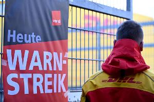 Ein warnstreikender DHL-Mitarbeiter an einem Standort der Post, die zu DHL gehört.
